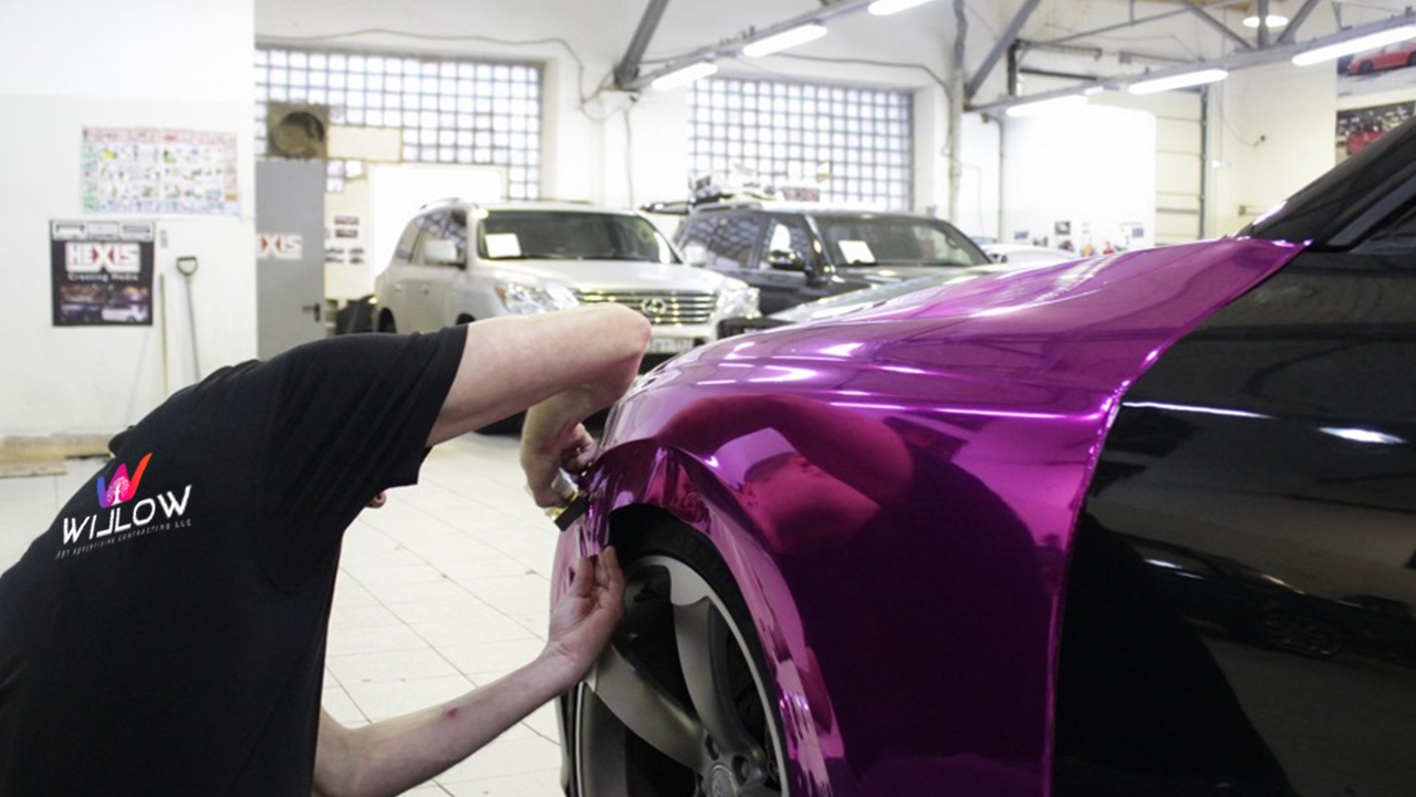 Willow Art Advertising technician installing a vibrant purple vinyl wrap on an Audi RS5 using HEXIS film.
