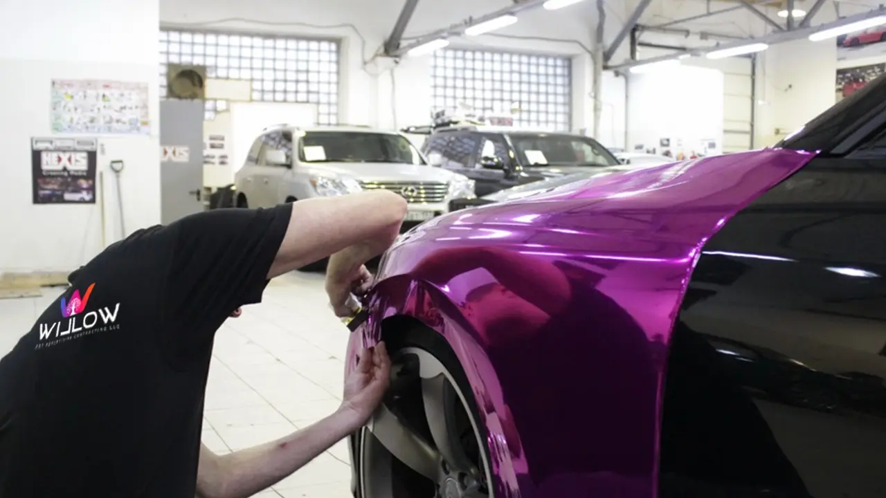 Willow Art Advertising technician installing a vibrant purple vinyl wrap on an Audi RS5 using HEXIS film.